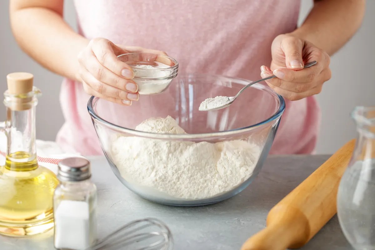 Sachets de levure chimique posés près d'un saladier de pâte à gâteau