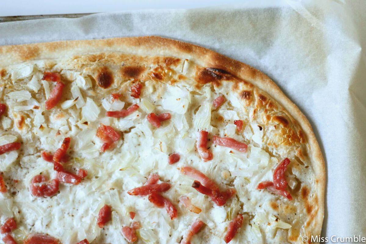Flamenkuch, tarte flambée alsacienne à pâte fine garnie de crème, d'oignons et de lardons fumés