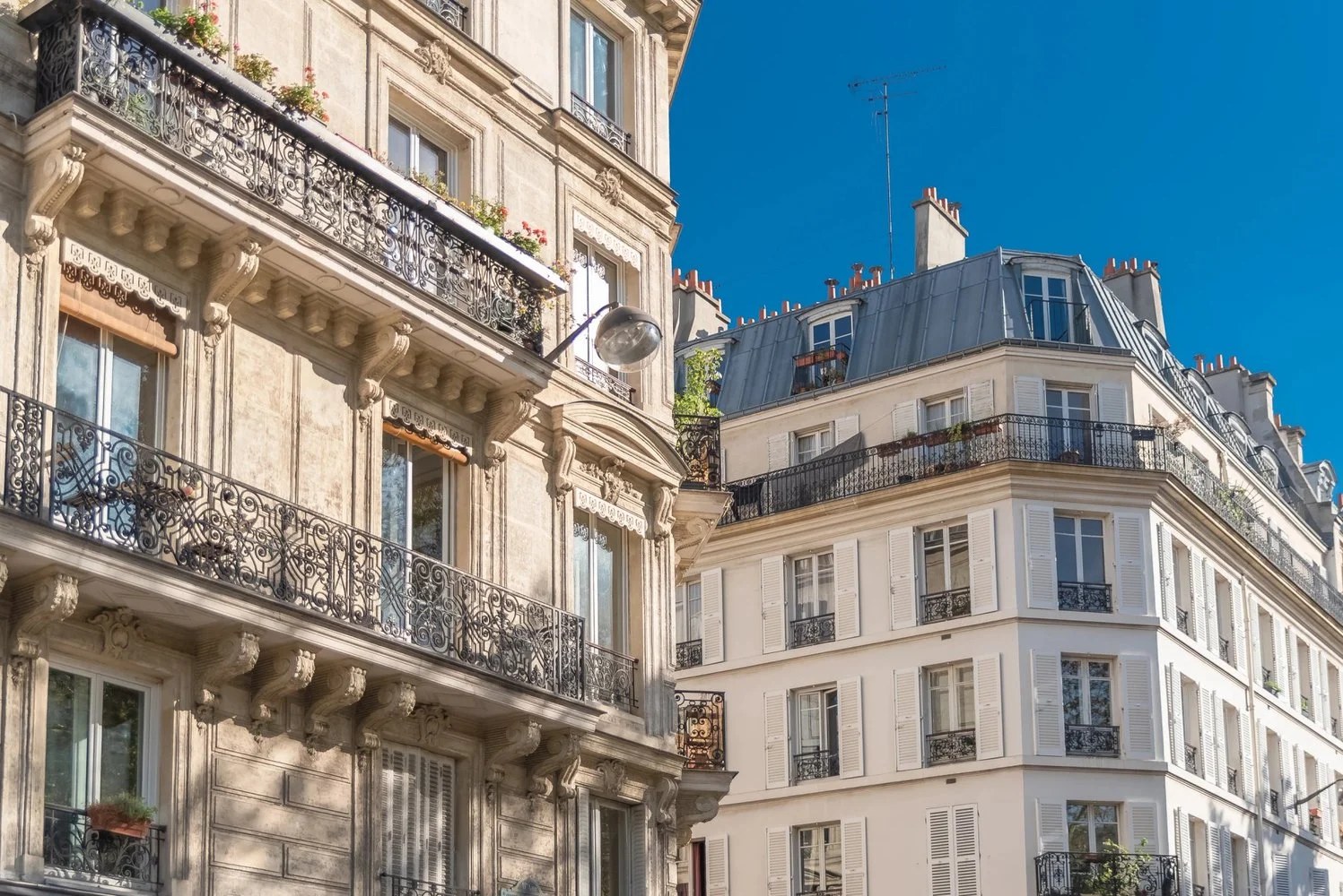 Rue parisienne animée avec façades, terrasse de café et commerces de quartier